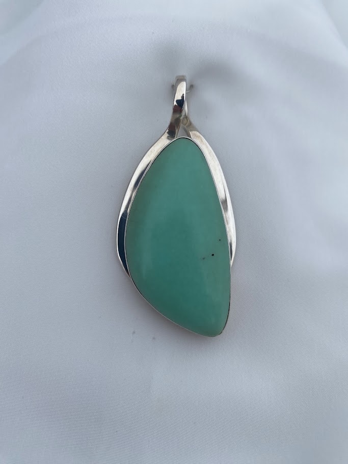 a green chrysoprase cabochon set into a sterling silver pendant
