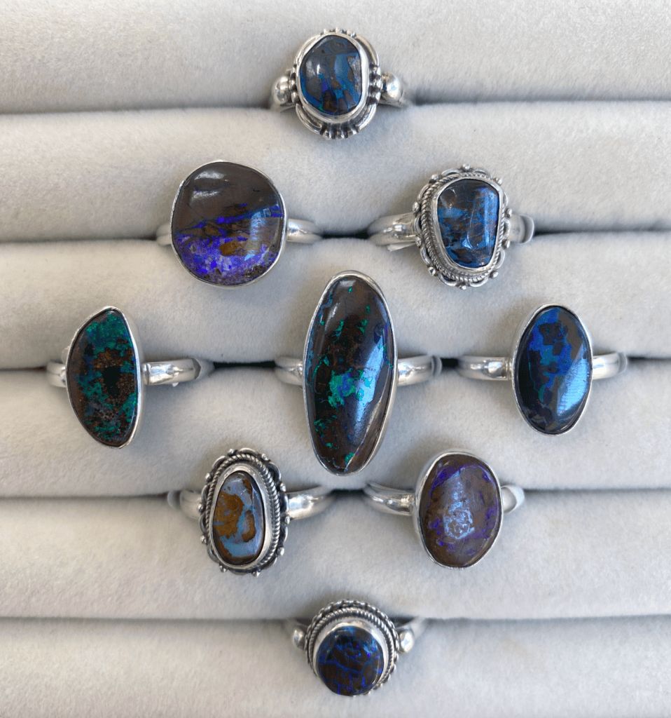 an assortment of boulder opal and sterling silver rings