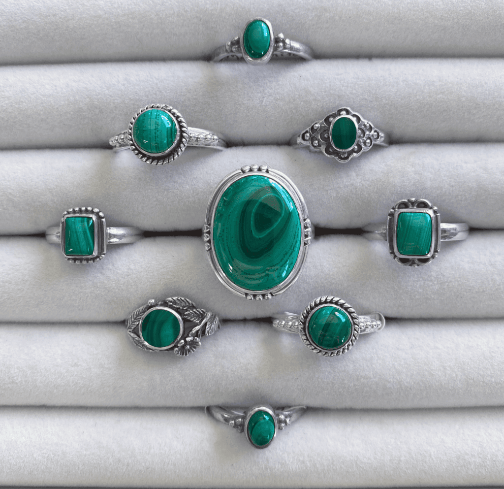 an assortment of malachite rings set in sterling silver