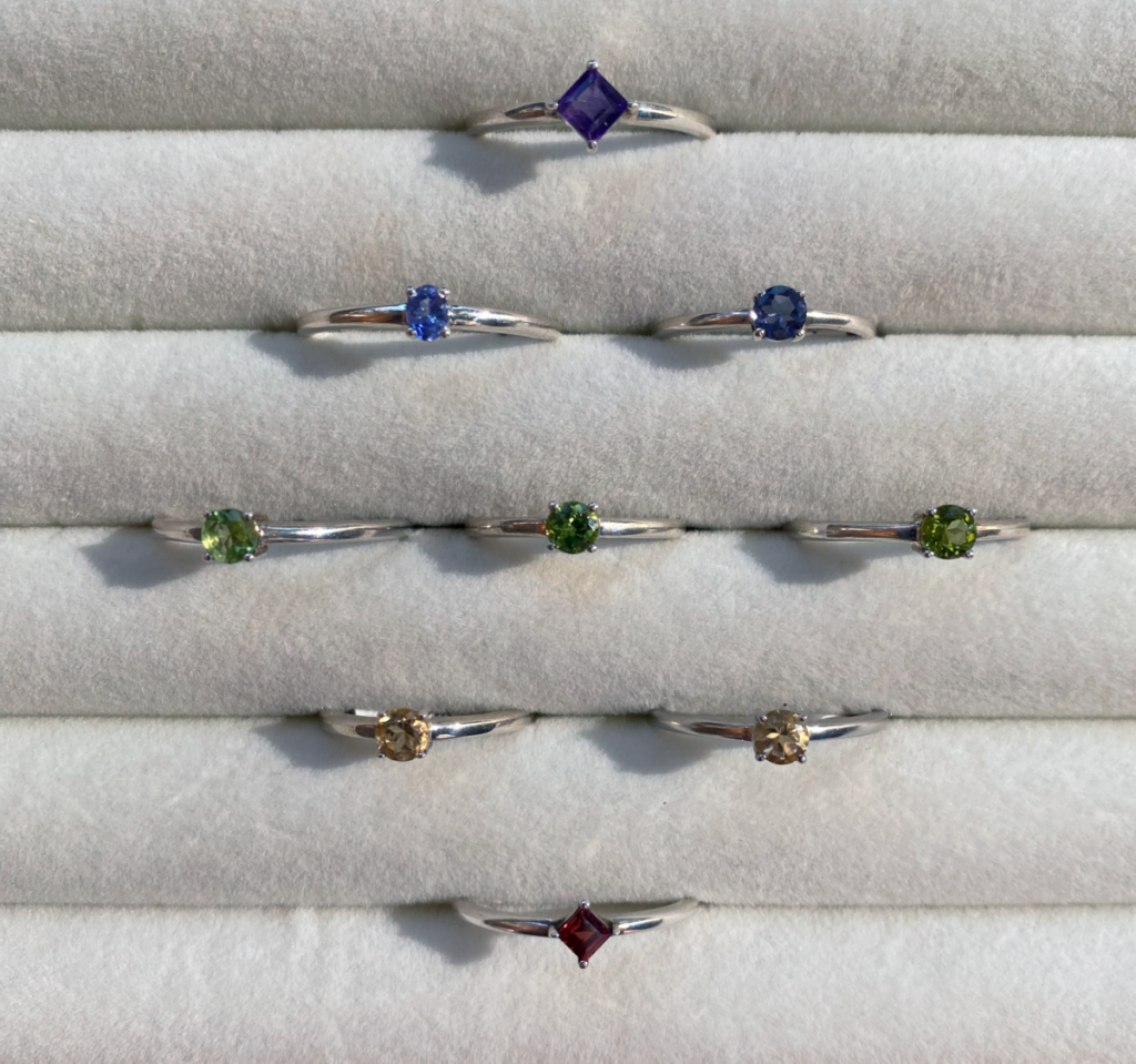an assortment of semi-precious gemstone and sterling silver rings including Amethyst, Iolite, Tanzanite, Peridot, Citrine, and Garnet
