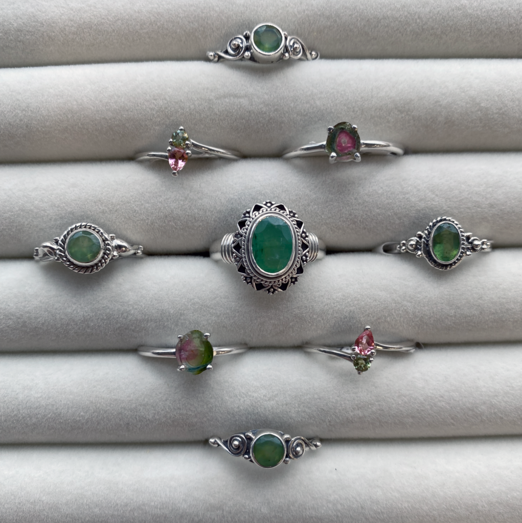 an assortment of semi-precious gemstone and sterling silver rings including Serpentine, Tourmaline, Chrysoprase, and Watermelon tourmaline